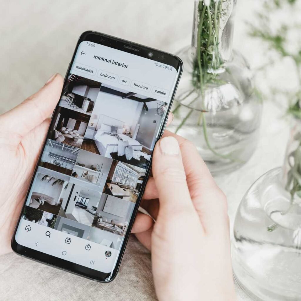 foto com pessoa segurando celular mostrando feed da sua rede social com trabalho de social media 2